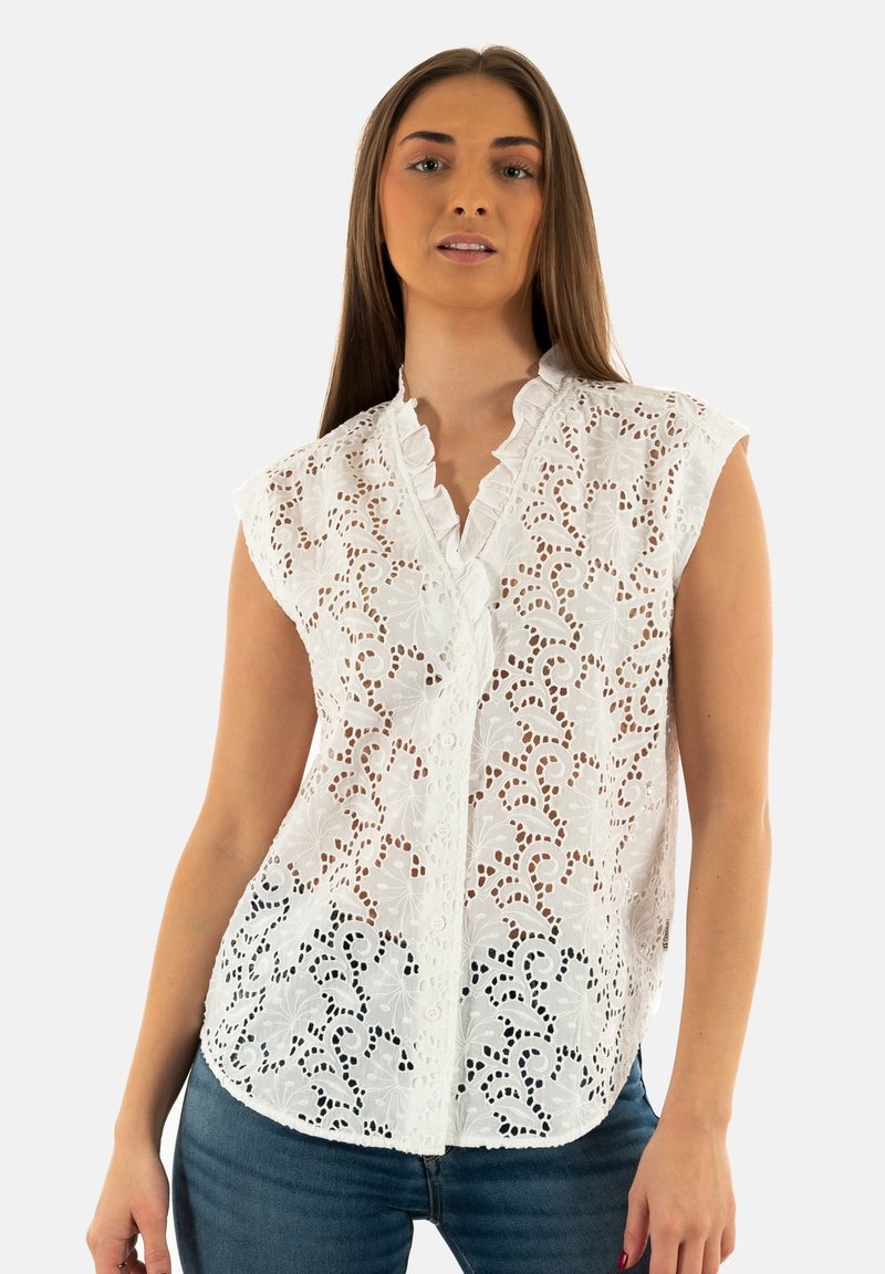 Witte blouse met ingewikkelde uitgesneden bloemembroidery, scalloped kraag en knoopsluiting. Mouwloos ontwerp en lichtgewicht stof.