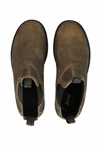 Botas de tobillo de ante marrón con una textura suave, paneles laterales elásticos y una lengüeta. Suelas de goma negras y una plantilla con marca.