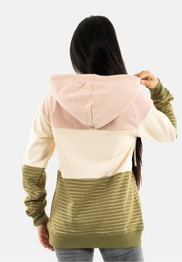 Sweat à capuche avec un design en blocs de couleurs rose, crème et vert olive, agrémenté de rayures horizontales et d'une texture douce.