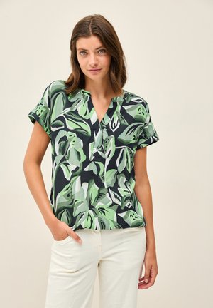 Camicia a maniche corte in tessuto leggero, con motivo a foglie verdi e nere, scollo a V e vestibilità rilassata. Tessuto dalla texture liscia.