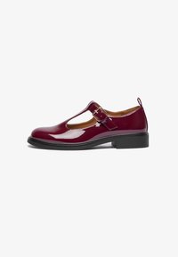 Chaussure Mary Jane en cuir verni bourgogne avec un bout arrondi, une bride T, une boucle ajustable et un petit talon carré. Texture lisse et design simple.