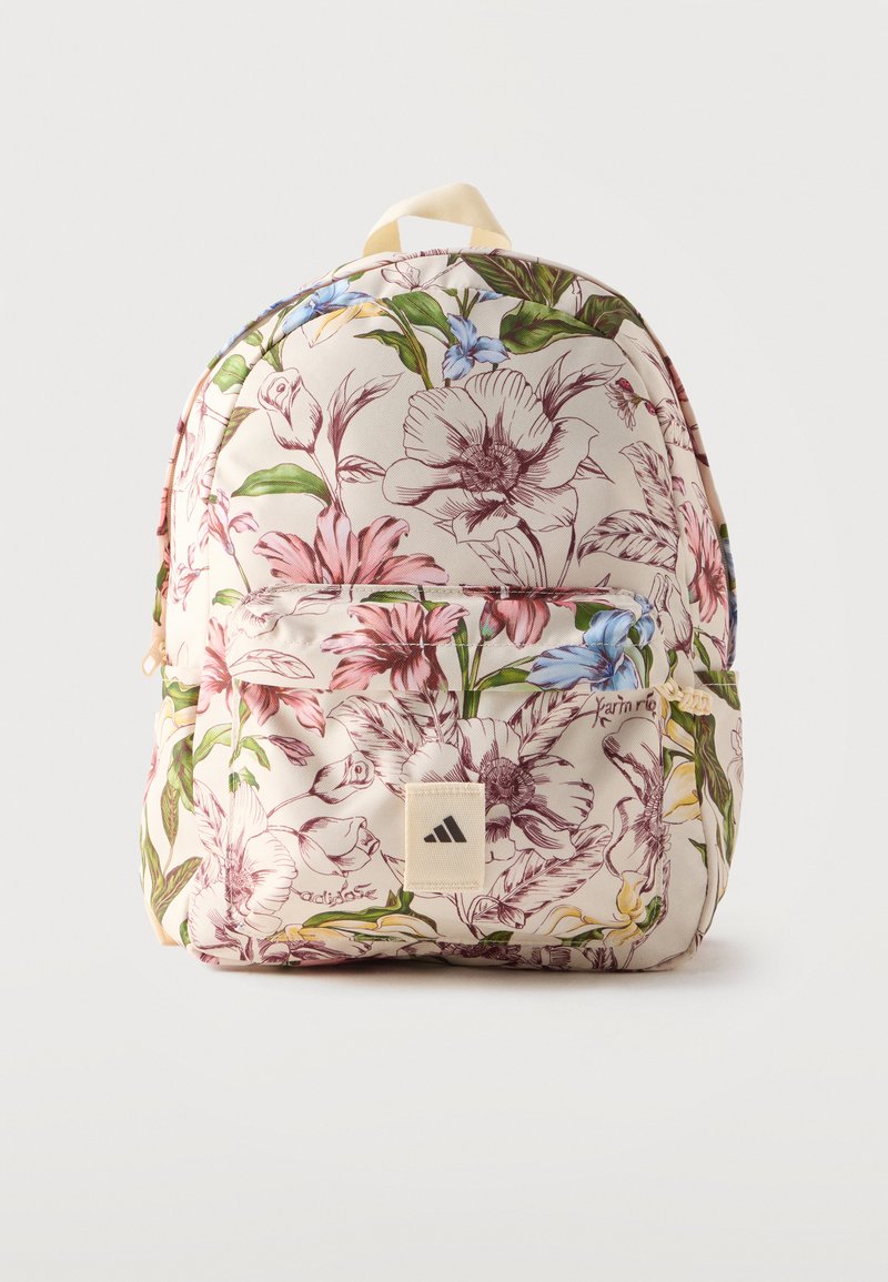 Sac à dos avec fond beige comportant des motifs floraux détaillés roses, bleus et verts et une poche avant avec un patch logo Adidas.
