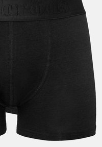 Schwarze Baumwoll-Boxershorts mit einem strukturierten Bund, der durch eingeprägte Markenlogos gekennzeichnet ist. Glattes, enganliegendes Design mit verstärkten Nähdetails.