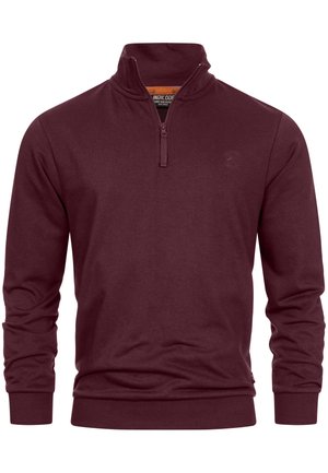 Felpa bordeaux con collo a zip quarti, polsini e orlo a costine. Realizzata in un tessuto morbido e liscio con una sottile texture.