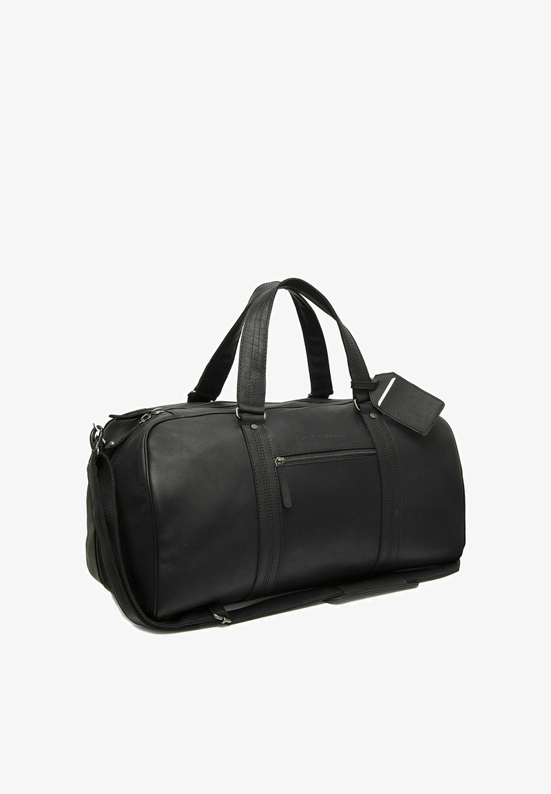 Sac de voyage en cuir noir avec double poignée, poche avant zippée, bandoulière détachable et étiquette à bagage attachée.