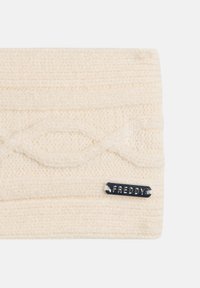 Cinta para la cabeza de punto color crema con un patrón de trenzado texturizado, que cuenta con una placa de metal plateada con el nombre de la marca "FREDDY" adjunta.