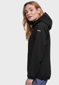 Schwarze wasserdichte Jacke mit Kapuze, ausgestattet mit einem Reißverschluss, elastischen Bündchen und einem Logo auf der Brust. Glatte, matte Stofftextur.