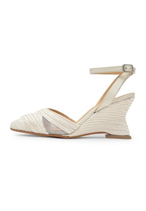 Sandalia de cuña beige con tira en el tobillo, tacón con textura tejida, punta abierta y detalles de malla y trenzados en la parte delantera.