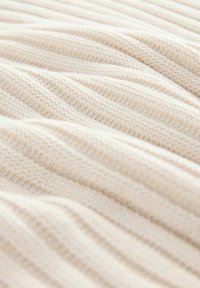 Tessuto lavorato a maglia avorio con una texture a costine, caratterizzato da sottili righe orizzontali e un aspetto morbido e liscio.