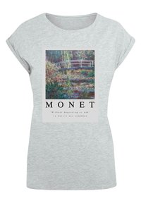 T-shirt en coton gris clair avec une impression à l'avant de la peinture des nénuphars de Monet, accompagnée de texte, col rond et manches retroussées.