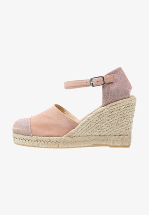 Růžové semišové klínové espadrilky s metalickým akcentem, řemínkem kolem kotníku a pletenou jutu podešví. Prsty mají texturovanou látkovou čepici.