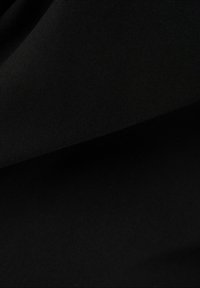 Svart tyg med slät struktur, med en något glänsande yta och mjuka veck, vilket indikerar ett lätt och elastiskt material.