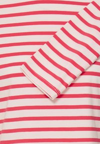 T-shirt rayé rouge et blanc, en coton, col rond, manches aux coudes, détails de coutures visibles, texture douce.