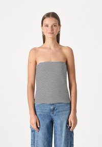 Pruhovaný černobílý crop top bez ramínek, přiléhavý design, měkká tkanina, hladká textura. Nosit s světle modrými cargo kalhotami.