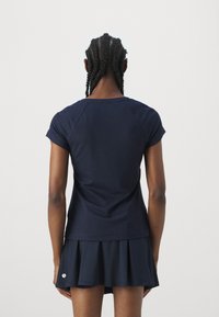 Granatowy top z krótkim rękawem typu raglan w zestawieniu z rozkloszowaną spódnicą. Miękka tkanina o gładkiej fakturze i subtelnym wzornictwie.