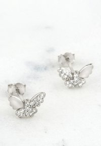 Silberne, schmetterlingsförmige Ohrringe, verziert mit funkelnden klaren Steinen. Strukturierte Flügel und mit einem Standard-Pin-Verschluss gesichert.