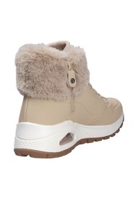 Botas de tobillo beige con un cuello de piel sintética, superficie lisa, cierre de cordones y una suela intermedia blanca con amortiguación de aire y suela marrón.