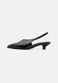 Fekete bőr slingback sarokcipők hegyes orral, nyitott oldalakkal és rövid, harang alakú sarkakkal. Simás textúra és minimalista dizájn.