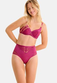 Bralette en dentelle magenta avec armatures et culotte taille haute assortie mettant en avant des accents en dentelle florale et un tissu lisse. Texture douce, design épuré.