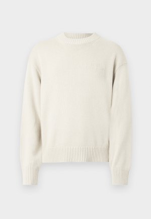 Cremefarbener Strickpullover mit rundem Ausschnitt, gerippten Bündchen und Saum, der ein dezentes, geprägtes Logo auf der Brust aufweist.