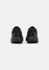 Chaussures de sport noires avec un dessus en mesh texturé, une semelle rembourrée et un talon renforcé. Conception minimaliste avec des détails de marque discrets.