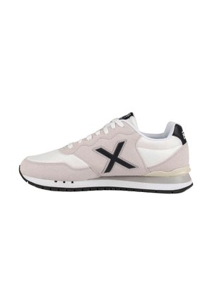 Zapatilla blanca y beige claro con logo negro en forma de X en el lateral, cordones blancos y detalle negro en el talón y la suela.