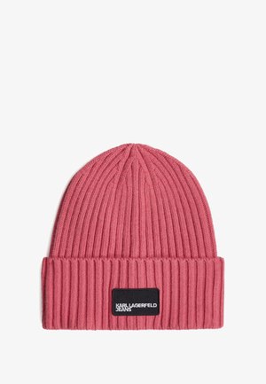 Rožinė megzta kepurė su raštuotu paviršiumi, turinti sulenkta apvadu ir juodą stačiakampį etiketę su užrašu "KARL LAGERFELD JEANS."
