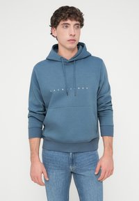 Μπλε βαμβακερή φούτερ μπλούζα με κουκούλα και τσέπη καγκουρό στο μπροστινό μέρος. Διαθέτει λευκό λογότυπο στο στήθος και ριμπ μανσέτες.