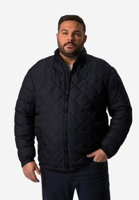 Marinblå kviltad pufferjacka med hög krage, framzipper, sidofickor och elastiska ärmar; har en strukturerad, isolerad design.