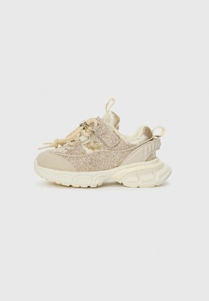 Glittery beige sneakers with textured fabric and smooth leather accents, featuring a cushioned sole and adjustable lace closure.