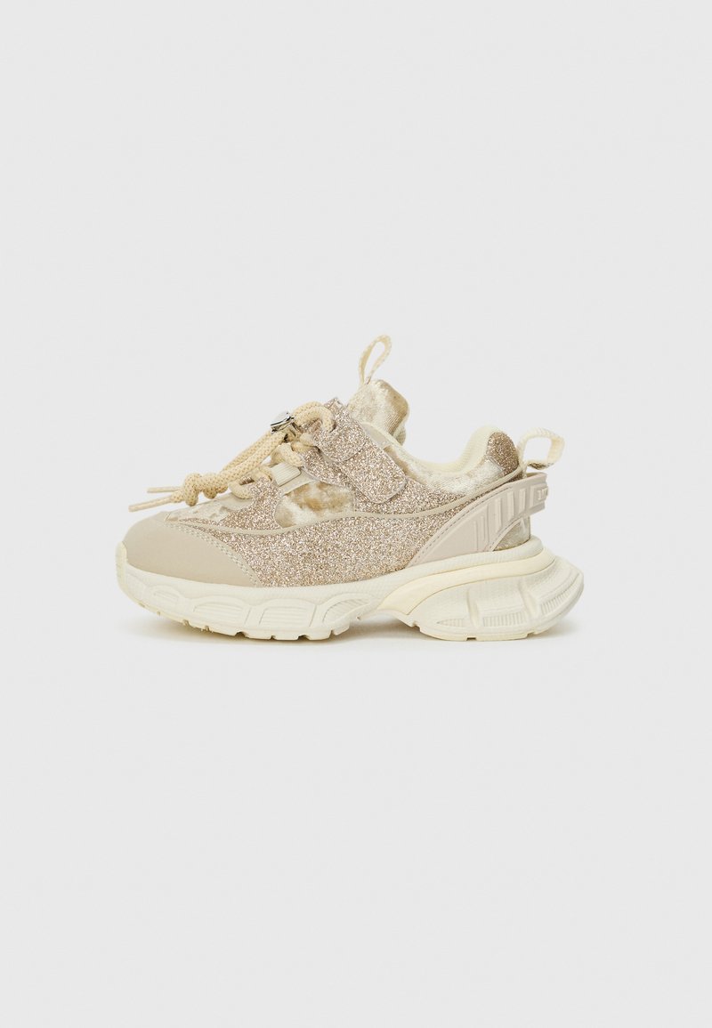 Glitzige beige Sneakers mit strukturiertem Stoff und glatten Lederakzenten, ausgestattet mit einer gepolsterten Sohle und einer verstellbaren Schnürung.