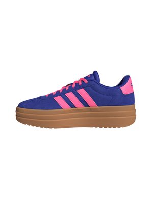 Blauer Sneaker mit pinken Streifen und Schnürsenkeln, pinkem Fersenlasche und dicker brauner Sohle, von der Seite auf weißem Hintergrund abgebildet.