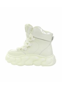 Białe wysokie sneakersy z błyszczącym wykończeniem, zaokrągloną, przerośniętą podeszwą oraz teksturowanym wiązaniem; wyściełany kołnierz i subtelne srebrne akcenty.