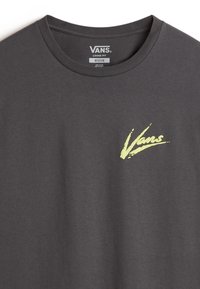 T-shirt Vans gris foncé coupe ample taille moyenne avec logo Vans jaune fluo sur la poitrine gauche et col rond côtelé.