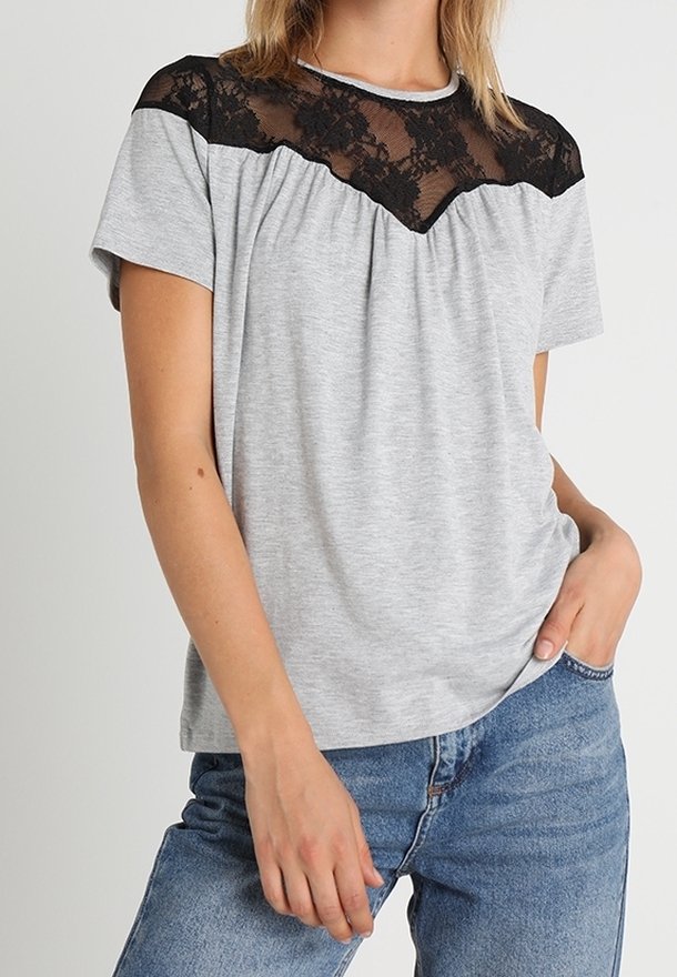 Camiseta gris de manga corta con un panel de encaje negro a lo largo de los hombros, con pliegues en el escote y un corte relajado.