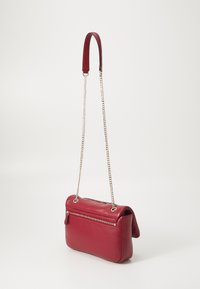 Borsa a spalla in pelle rossa con tracolla a catena, tasca con zip sulla parte frontale e una forma liscia e strutturata. Cuciture sottili che evidenziano il design.
