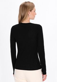Zwarte lange mouwen shirt met een ronde hals, gemaakt van lichtgewicht stof, voorzien van een eenvoudig ontwerp en een gladde textuur, gezien van achteren.