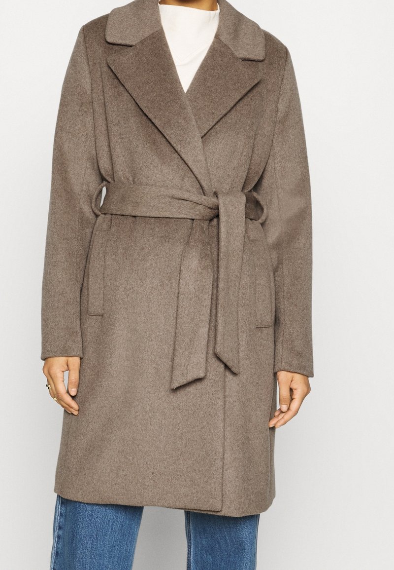 Abrigo de mezcla de lana marrón con cintura ceñida, frente abierto, cuello muesca y mangas largas. Tejido texturizado con un diseño limpio y minimalista.
