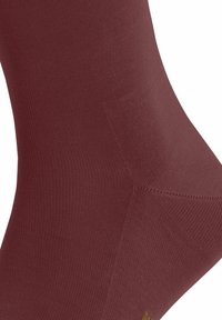Burgunderfarbene Socke mit gerippter Textur, verstärkter Zehen- und Fersenbereich. Elastisches Material für eine angenehme Passform.