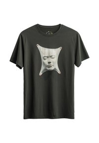 Donkergroen katoen T-shirt met een afbeelding van een gezicht binnenin een vervormde stoffen vorm. Bevat rode accenten in de hoeken.