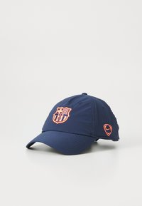 Marineblauwe baseballcap van stof, met een geborduurd oranje FC Barcelona-logo en een klein oranje Nike-logo aan de zijkant.