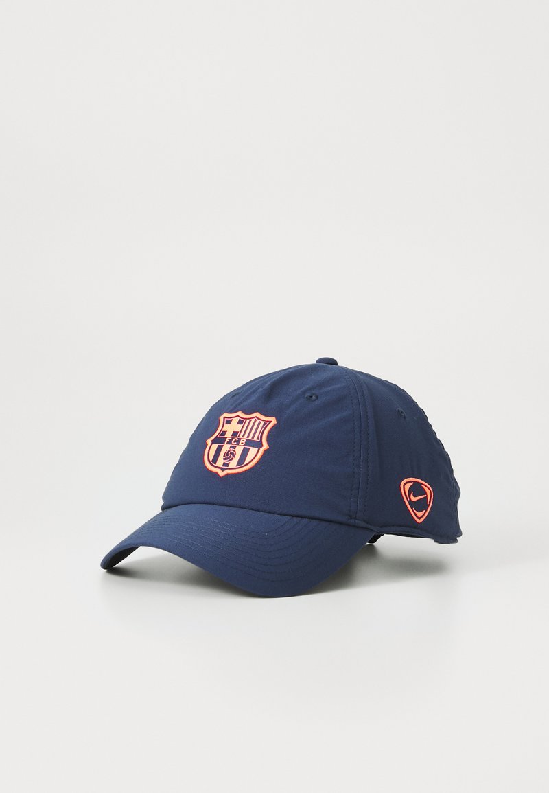 Marineblauwe baseballcap van stof, met een geborduurd oranje FC Barcelona-logo en een klein oranje Nike-logo aan de zijkant.