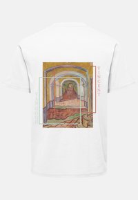 T-shirt bianca con una pittura di Vincent van Gogh che raffigura un corridoio ad arco. Il design include contorni colorati e testo in verde e rosso.