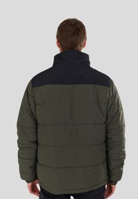 Padded jacket in olive green with a black yoke. Features a high collar and horizontal quilted design. Soft texture with elastic cuffs.
