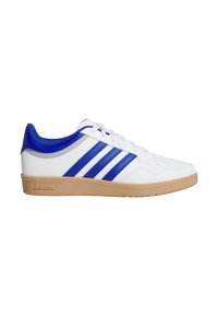 Zapatilla deportiva blanca con detalles en azul, que presenta tres rayas azules, una suela de goma texturizada y una parte superior lisa con apariencia de cuero.