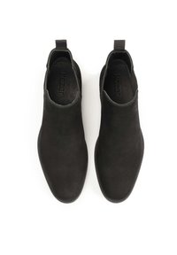 Bocanci ankle din suede negru cu un finisaj neted, panouri laterale elastice și tab-uri pentru o îmbrăcare ușoară. Prezintă un design cu vârf ascuțit.