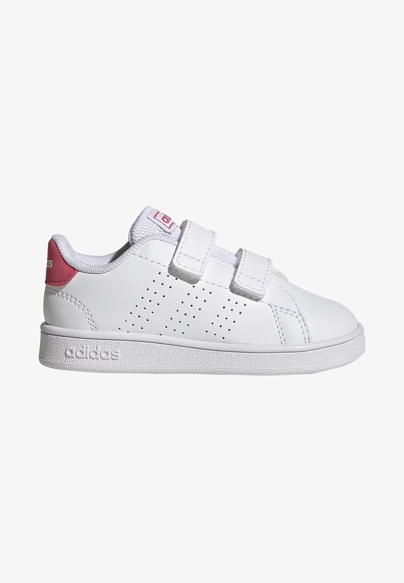 Hvide sneakers med velcro-stropper, tekstureret gummisål, perforeret design på siderne og lyserøde accenter på hælen og tungen.