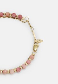 Gold chain bracelet featuring pink faceted beads and small gold accents, with a lobster clasp for secure fastening.