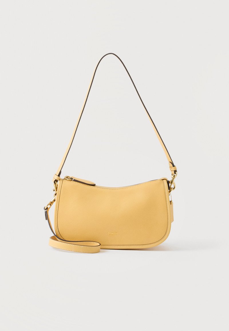 Κίτρινη δερμάτινη τσάντα ώμου με καμπυλωτό φερμουάρ στην κορυφή και λεπτό ρυθμιζόμενο λουράκι, μινιμαλιστικός σχεδιασμός σε απλό φόντο.