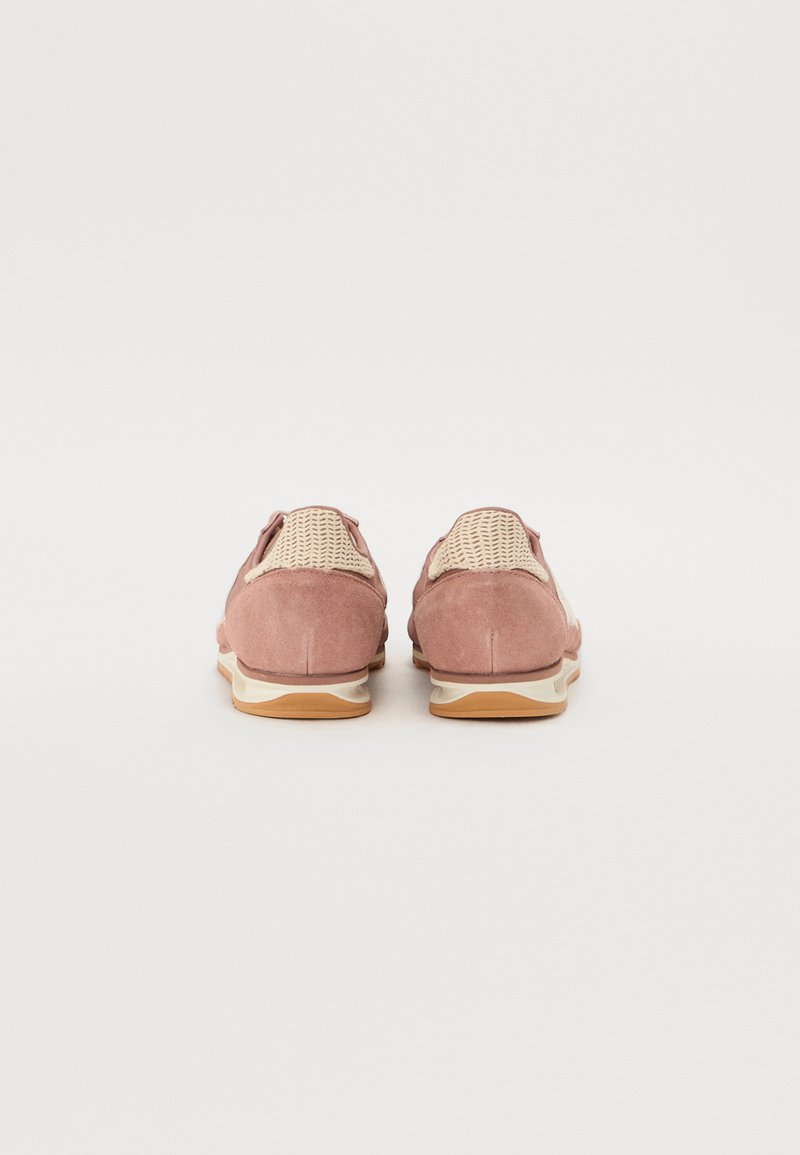 Chaussures en suède de couleur rose doux avec des accents tissés, bout rond et semelle intermédiaire blanche. La semelle extérieure en caoutchouc plate offre une bonne traction.